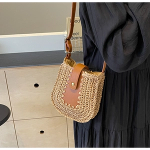 Détail du sac bandoulière en paille avec lanière en cuir marron et boucle dorée chic