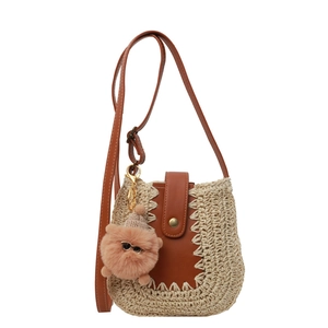 Sac bandoulière en paille avec garniture en cuir marron et pendentif pelucheux