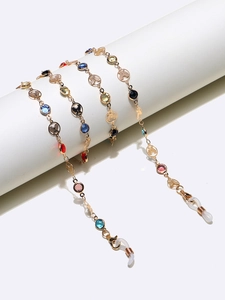 Close-up of golden butterfly eyewear chain with vibrant colorful glass beads and rubber loops