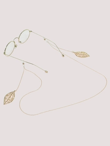 Detailed view of golden metal eyewear chain with elegant hollow leaf pendants and slim frame