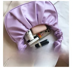 Close-up of lilac ruched cloud bag interior showing phone, wallet, and lipstick capacity