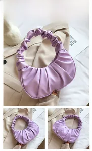 Detail view of purple ruched cloud handbag featuring soft PU leather and crescent design