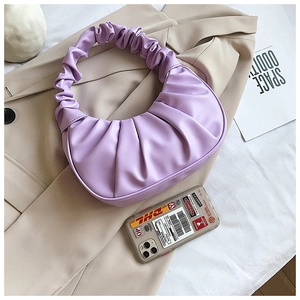 Top-down view of a light purple pleated cloud bag on a trench coat for summer style