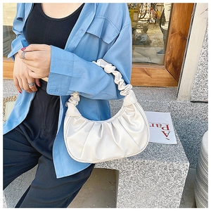 Detail of white pleated shoulder bag featuring elegant shirring on the soft PU strap