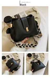 Detail of black leather bucket bag with stylish black and white wave pattern wide strap