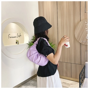 Fashionable lavender pleated cloud hobo bag carried on shoulder in a modern cafe setting