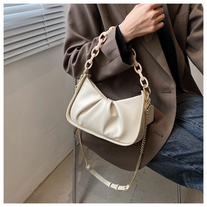 Detail view of off-white ruched cloud bag with acrylic chain strap on model