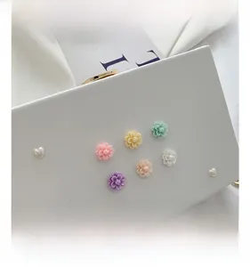 Detail der weißen Leder-Box-Tasche mit 3D-Harzblumen, Herzperlen und Goldverschluss