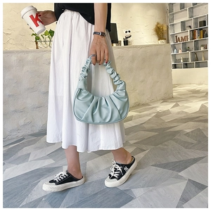Detail of mint green pleated cloud bag showing the soft PU leather texture and ruched handle