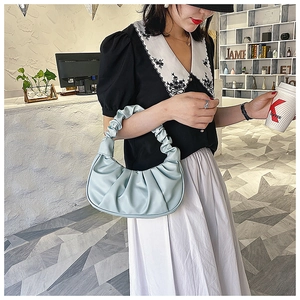 Detailed close-up of a mint green pleated cloud bag featuring soft PU leather texture