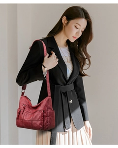 Fashionable dark red soft leather crossbody bag with multiple pockets shown on model