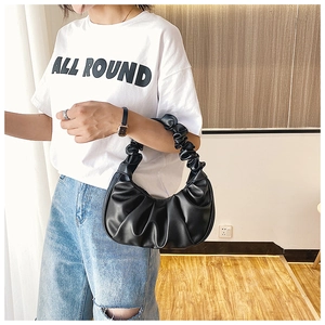 Detail of black pleated PU shoulder bag showing soft cloud-style handle and textures