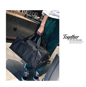 Detail of a black sports bag with durable handles and side metal buckle for shoulder strap