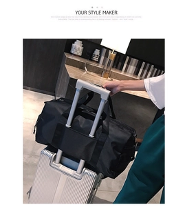 Travel bag back strap detail shown over suitcase handle for gym and sports use