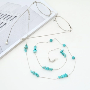 Chaîne de lunettes tendance avec perles de turquoise et chaîne en argent sur fond blanc