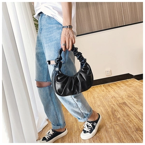 Detail of the black ruched PU leather handbag showing texture and pleated handle