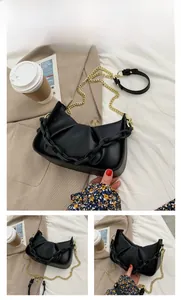 Detail of black cloud pleated shoulder bag with acrylic chain and gold metal strap