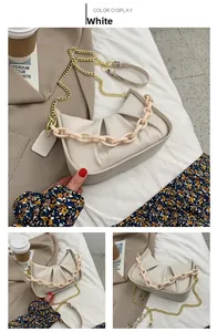 Detail of white cloud bag with matte acrylic chain and gold metal shoulder strap