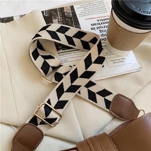 Detailed view of an adjustable woven shoulder strap with geometric patterns and gold clips