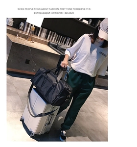 Detail of black sports travel bag featuring luggage sleeve for trolley suitcase attachment