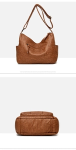 Detail view of brown leather shoulder bag featuring textured finish and zipper pockets