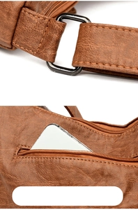 Macro shot of brown leather bag with metal D-ring hardware and zipper pocket for smartphone