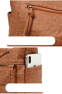 Detail of brown vintage faux leather bag showing back zipper pocket and side phone pocket