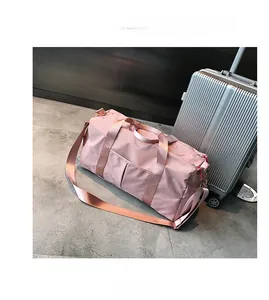 Detailed view of pink travel bag with waterproof nylon texture and adjustable shoulder straps