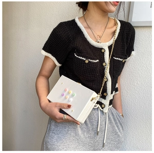 Detailansicht der weißen Box-Tasche mit 3D-Blumen und Goldkette am Model getragen