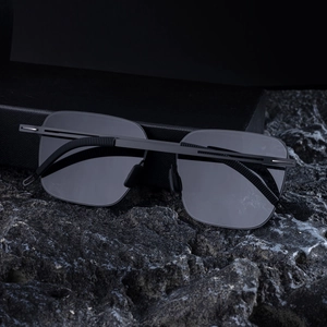 Detailed view of square polarized sunglasses with non-slip temples on dark basalt rock
