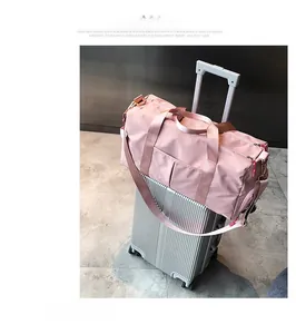 Pink travel bag with integrated sleeve secured on a silver luggage trolley handle