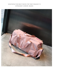 Pink waterproof fitness travel bag with shoulder strap shown from a side view angle