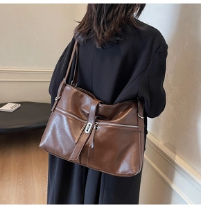 Détail du sac cabas marron vintage avec boucle en métal et poches zippées pratiques