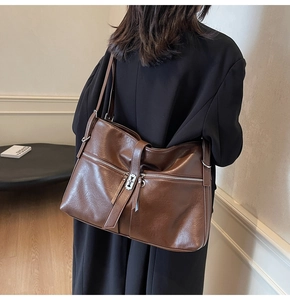 Détail d'un grand sac fourre-tout marron foncé avec fermetures éclair argentées