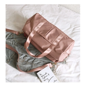 Detail of a mauve yoga gym bag with golden metal hardware and a detachable shoulder strap