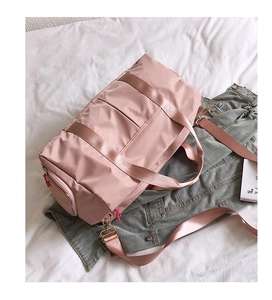 Pink nylon sports bag featuring a dedicated shoe compartment and detachable shoulder strap