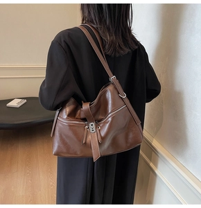 Détail du grand sac cabas en cuir marron foncé avec texture lisse et large bandoulière