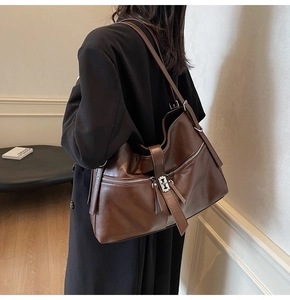 Détail du grand sac cabas vintage en cuir marron avec zips et texture élégante