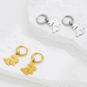 French vintage rabbit hoop earrings in gold and silver finish on stone background