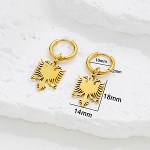 Golden stainless steel hoop earrings with Albania eagle pendant on stone surface