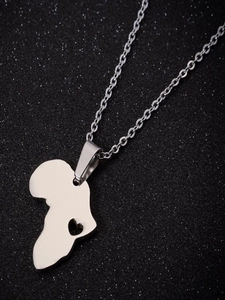 Détail du pendentif carte d'Afrique argenté avec découpe de cœur sur chaîne acier poli