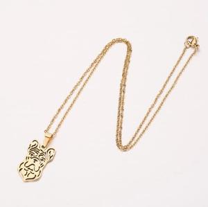 Détail du pendentif bouledogue français doré sur une fine chaîne de collier à maillons