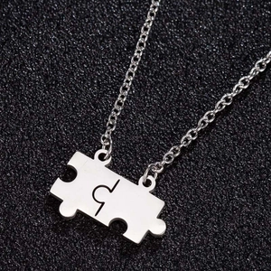 Macro shot of silver stainless steel interlocking puzzle piece pendant necklace