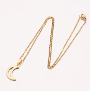 Close-up of minimalist gold crescent moon pendant with fine twisted chain on soft background