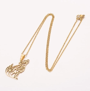 Detail of a gold geometric cutout howling wolf pendant necklace with a fine chain link