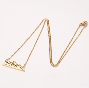 Détail du collier avec pendentif silhouette de montagne doré et fine chaîne à maillons O