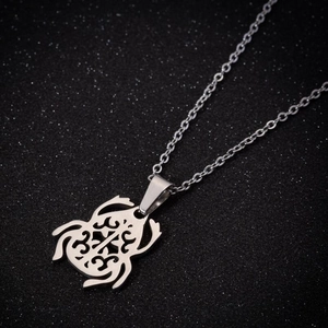Collier avec pendentif grenouille évidé en acier inoxydable argenté sur fond noir élégant