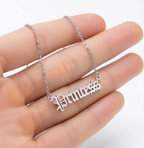 Detailaufnahme der silbernen Princess-Halskette in gotischer Schrift an der Hand