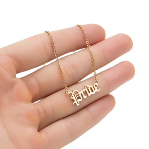 Gold stainless steel gothic 'Bride' letter pendant necklace held in hand on white background
