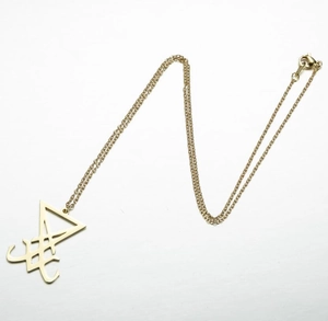 Gros plan du pendentif Sceau de Lucifer en acier doré avec motif géométrique ajouré détaillé